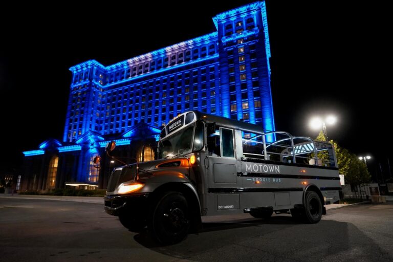 Motown Boogie Bus parked in front of Detroit skyline